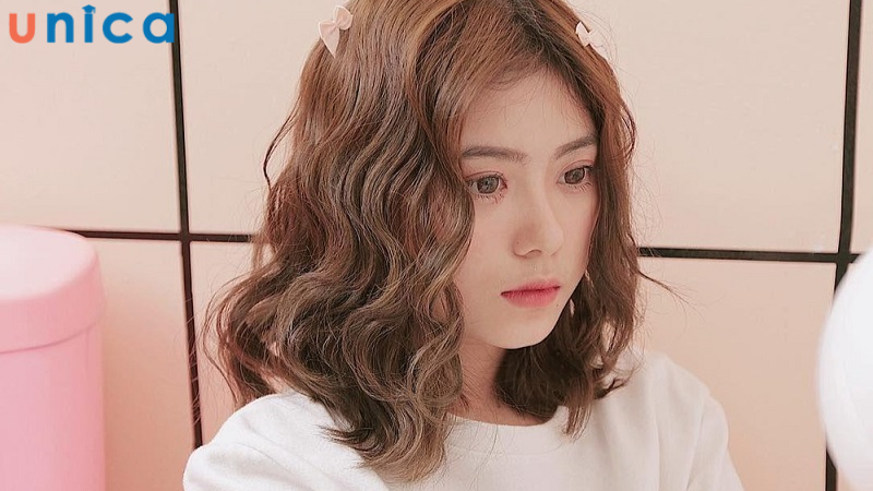 Tóc ngắn xoăn sóng nước lọn to phù hợp với những nàng có mặt dài